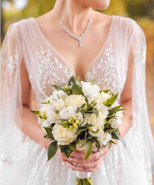 Dani's dress day of holding her bouquet with diamond necklace.